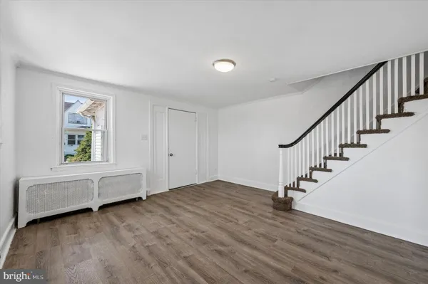 an empty room with wooden floor and a window