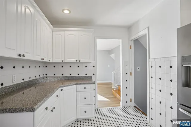 a kitchen with granite countertop a refrigerator and a stove