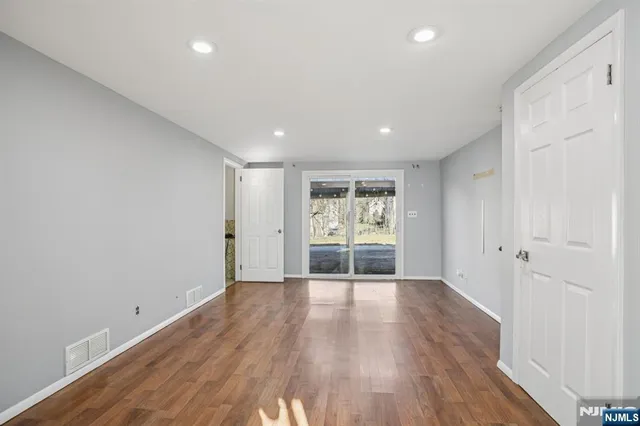 a view of a room with wooden floor and window