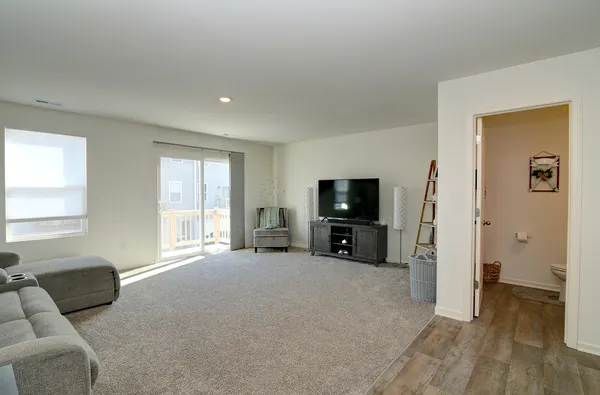 a living room with furniture a flat screen tv and a large window
