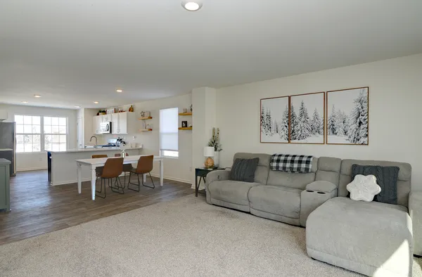 a living room with furniture and a dining table with window