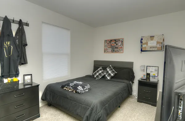 a bedroom with a bed and a night stand