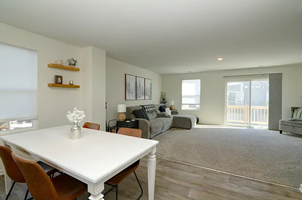 a view of a a dining room with furniture window and wooden floor