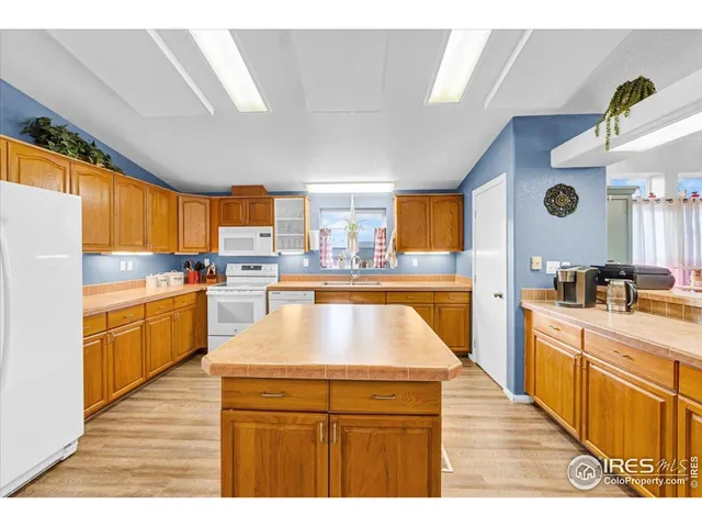 a kitchen with kitchen island granite countertop a sink a counter top space and stainless steel appliances