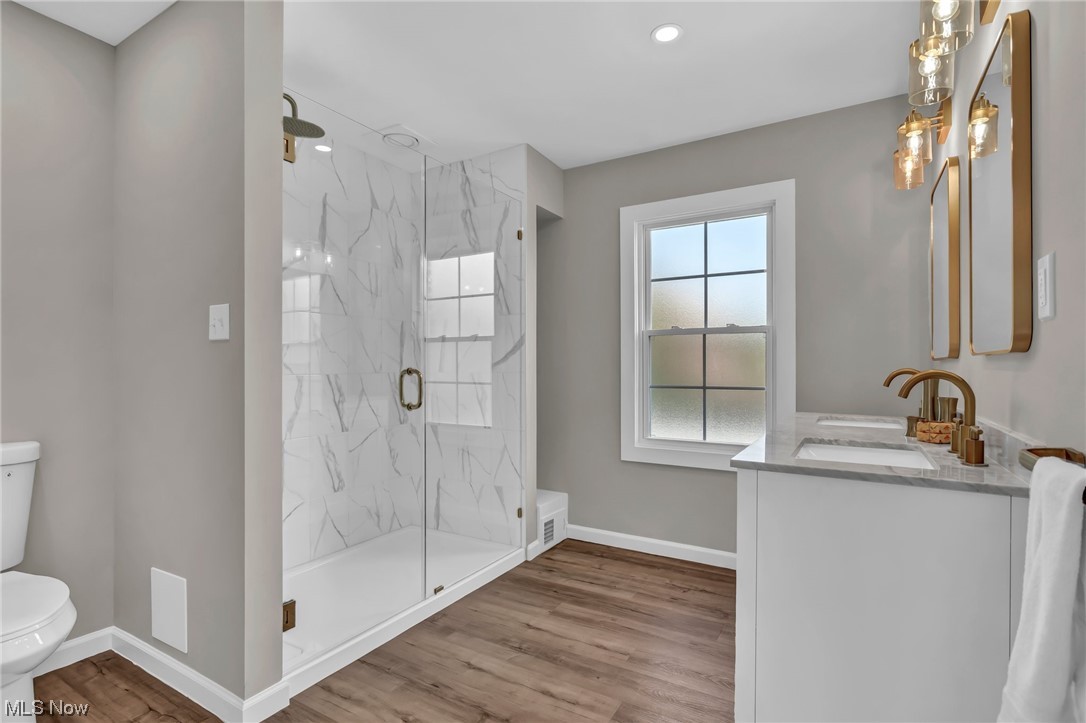 3669 Silsby Road University Heights, OH 44118 - Photo 23 of 34 Owners en-suite bathroom featuring a large tiled shower, large dual sink vanity, mirror, and LVT floors