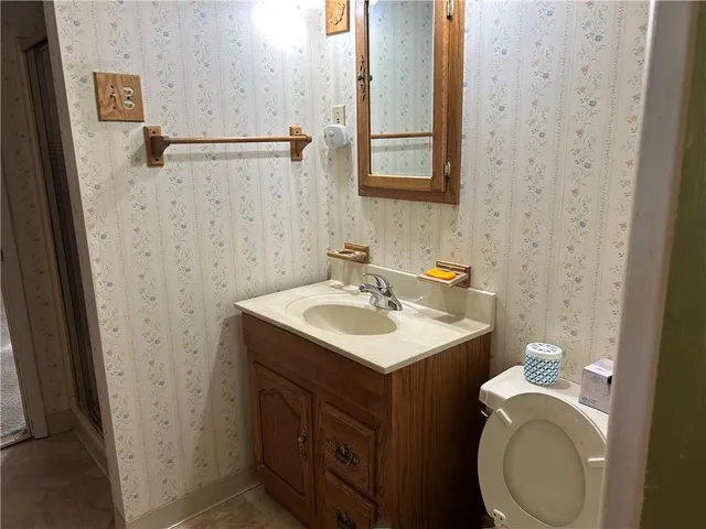 a bathroom with a sink toilet and mirror