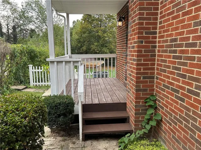 a view of a deck in backyard of house