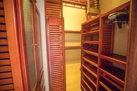 a view of walk in closet with clothes and shoes