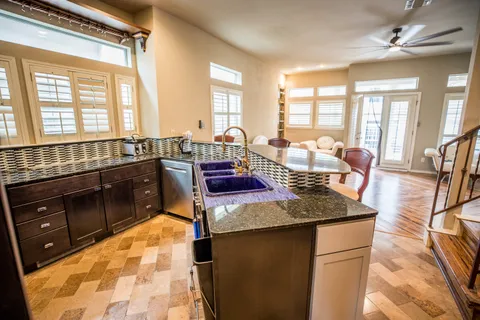 a large kitchen with kitchen island a large counter top space a sink a window and stainless steel appliances