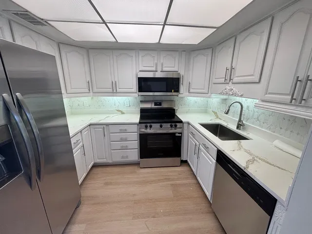 a kitchen with a sink stove and refrigerator