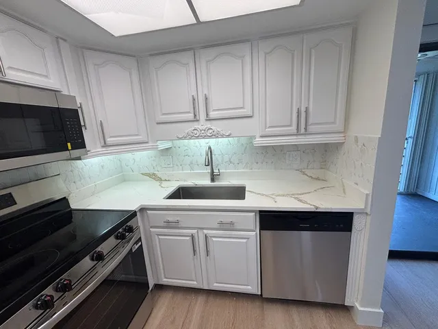 a kitchen with cabinets appliances and a sink