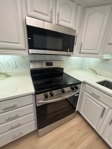 a kitchen with stainless steel appliances wooden cabinets and a stove top oven