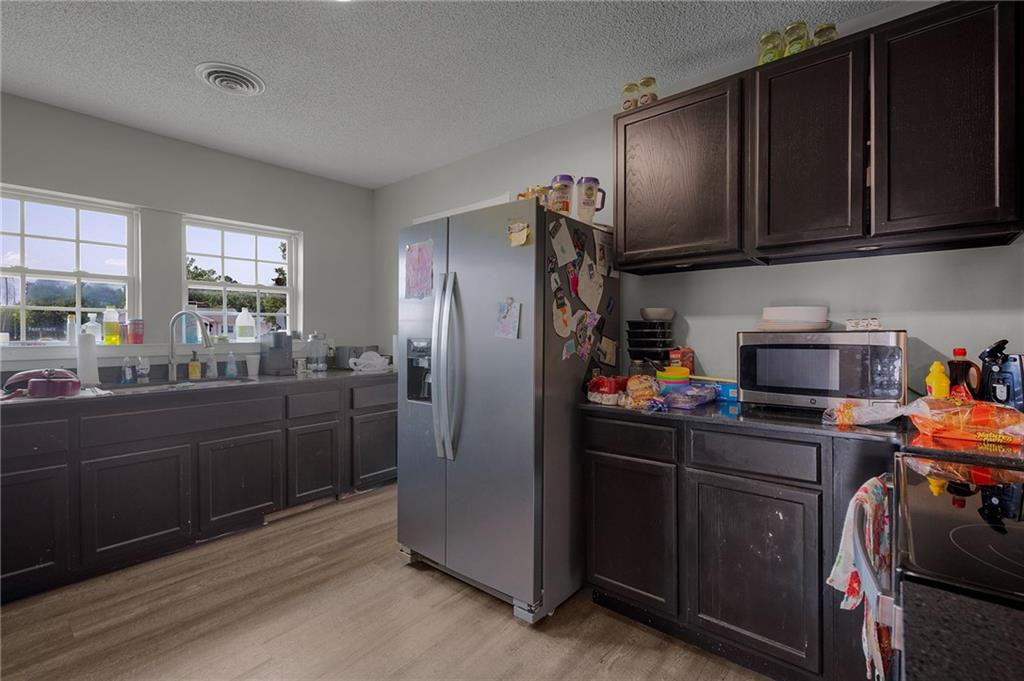 2213 Cleveland Highway Dalton, GA 30721 - Photo 29 of 41 a kitchen with stainless steel appliances granite countertop wooden cabinets a refrigerator a stove a sink and dishwasher with wooden floor