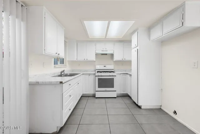 a kitchen with a stove sink and cabinets