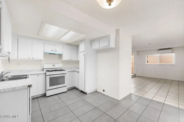 a kitchen with granite countertop white cabinets and appliances