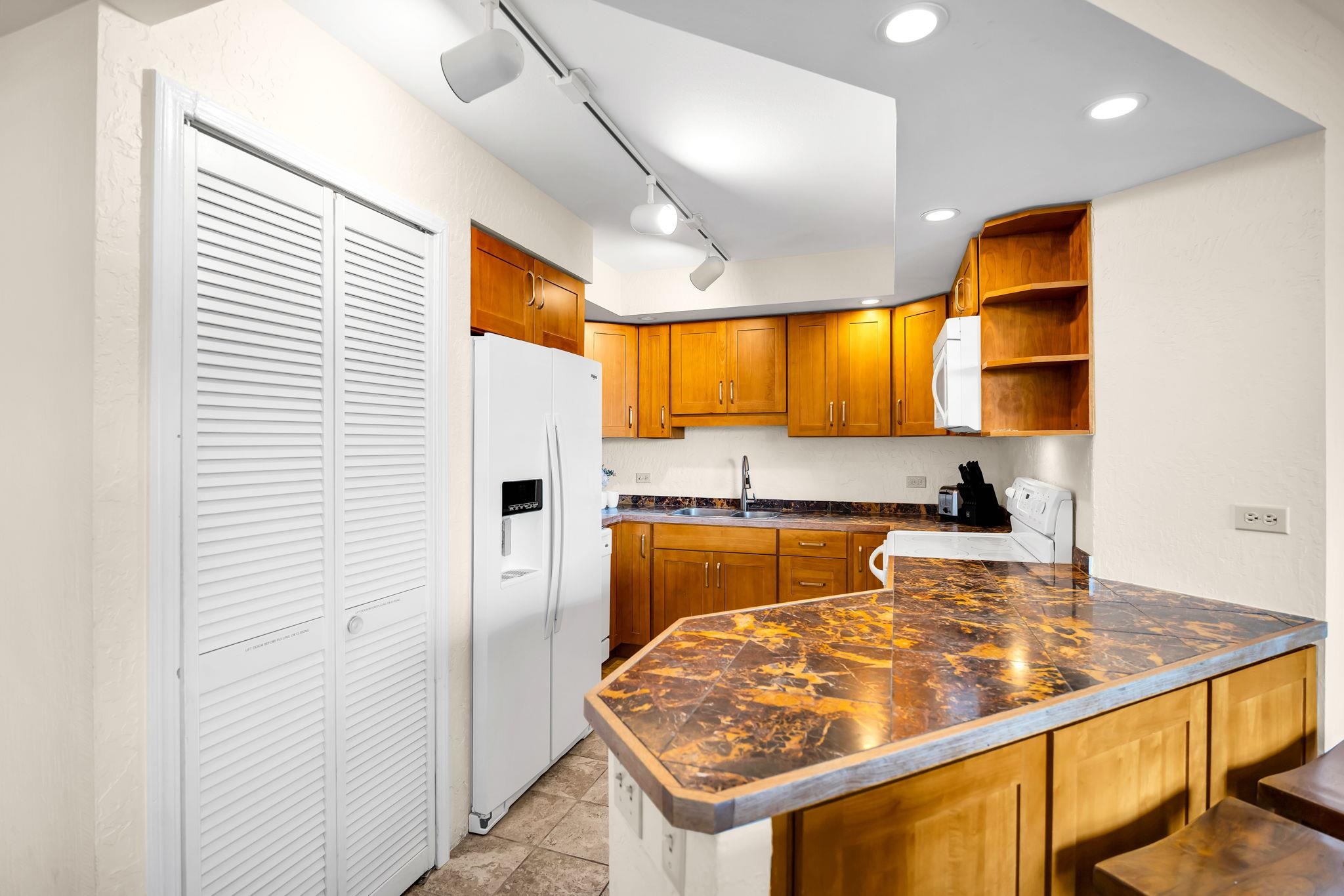 3445 Lower Honoapiilani Road, Unit 516 Lahaina, HI 96761 - Photo 19 of 49 a kitchen with stainless steel appliances granite countertop sink stove and refrigerator