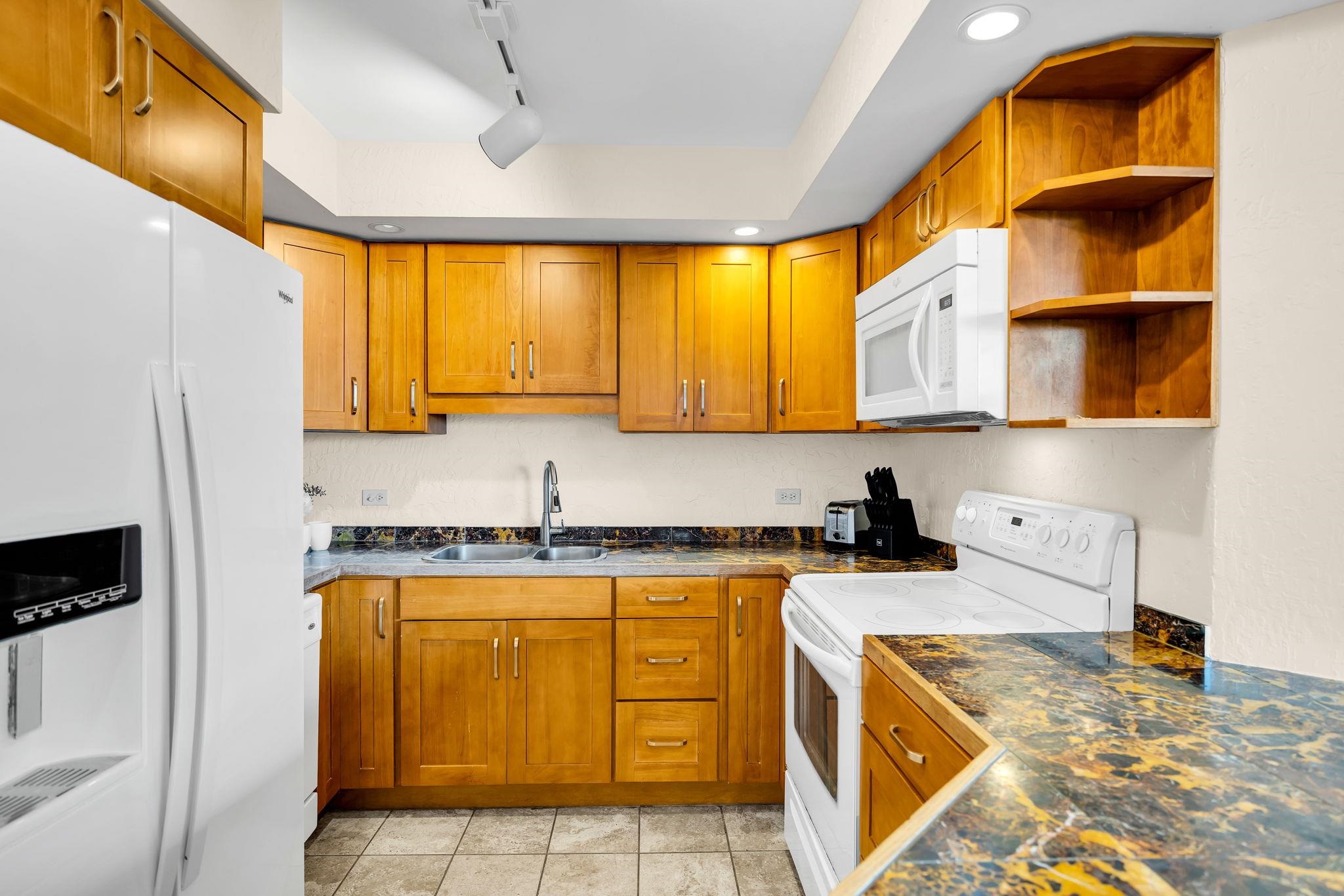 3445 Lower Honoapiilani Road, Unit 516 Lahaina, HI 96761 - Photo 21 of 49 a kitchen with stainless steel appliances granite countertop a sink a stove and a refrigerator