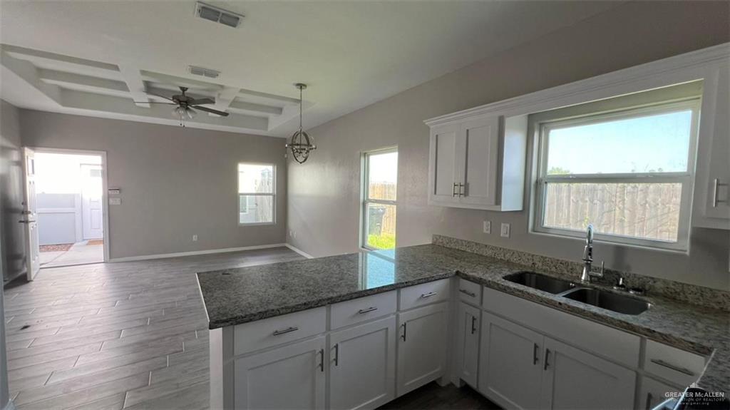 2108 Redbud Lane Weslaco, TX 78596 - Photo 7 of 9 a kitchen with granite countertop a sink stainless steel appliances white cabinets and a window
