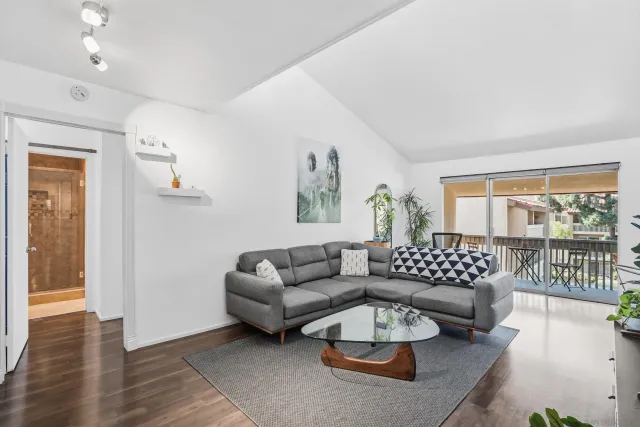 a living room with furniture and a wooden floor