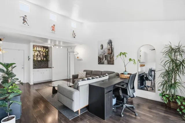 a living room with furniture a potted plant and a table