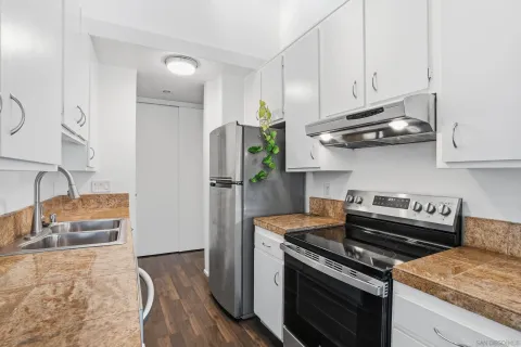 a kitchen with stainless steel appliances granite countertop a stove a refrigerator and a wooden cabinets