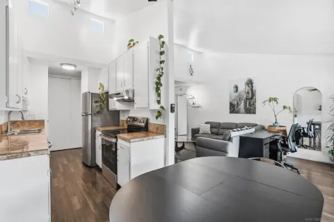 a large living room with stainless steel appliances kitchen island granite countertop a stove a sink a refrigerator and a dining table view