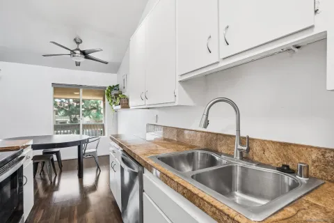 a kitchen with a sink table and chairs