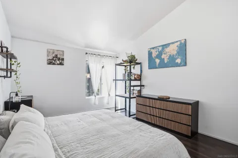 a bedroom with a bed and a painting on the wall