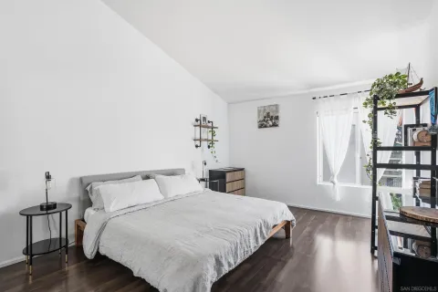 a bedroom with a bed and a wooden floor