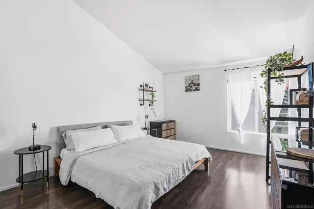 a bedroom with a bed and a wooden floor