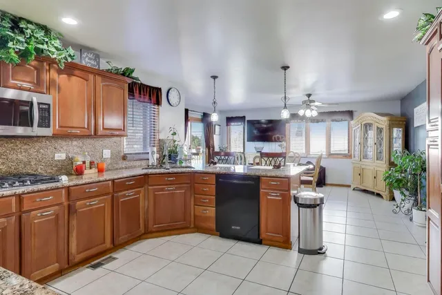a kitchen with stainless steel appliances granite countertop a sink dishwasher stove and cabinets