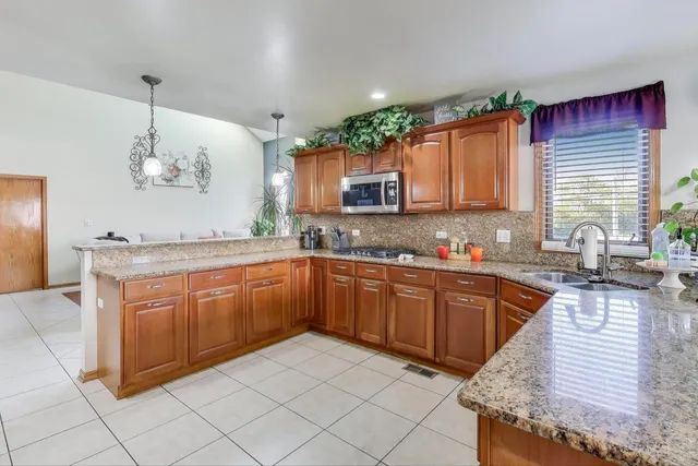 a kitchen with stainless steel appliances granite countertop a refrigerator and a sink