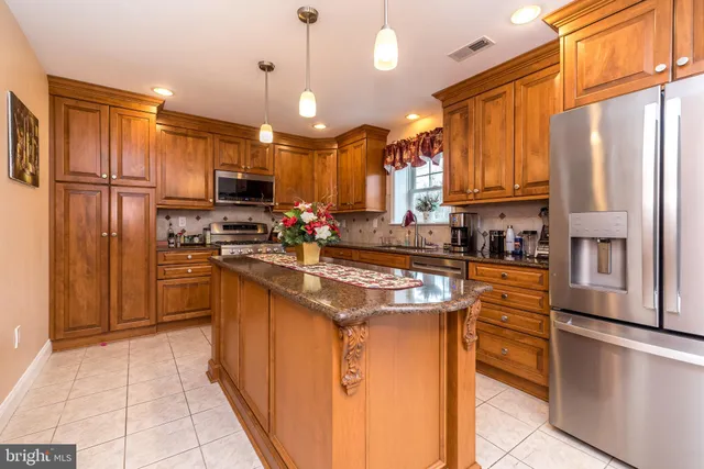 a kitchen with stainless steel appliances granite countertop a refrigerator a stove a sink and a refrigerator