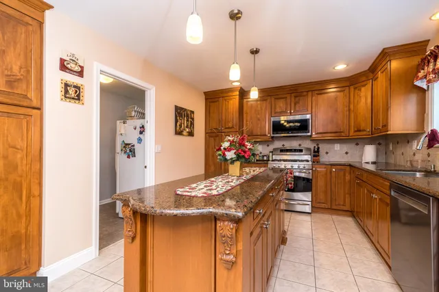 a kitchen with kitchen island granite countertop a sink counter top space stainless steel appliances and a window