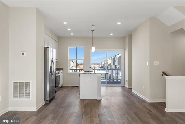 a kitchen with stainless steel appliances granite countertop wooden floors sink and stove