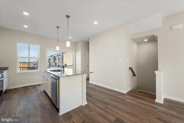 a kitchen with granite countertop a sink stainless steel appliances and cabinets