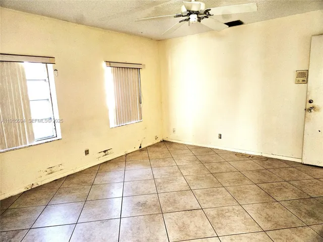 a view of a room with a window and chandelier fan