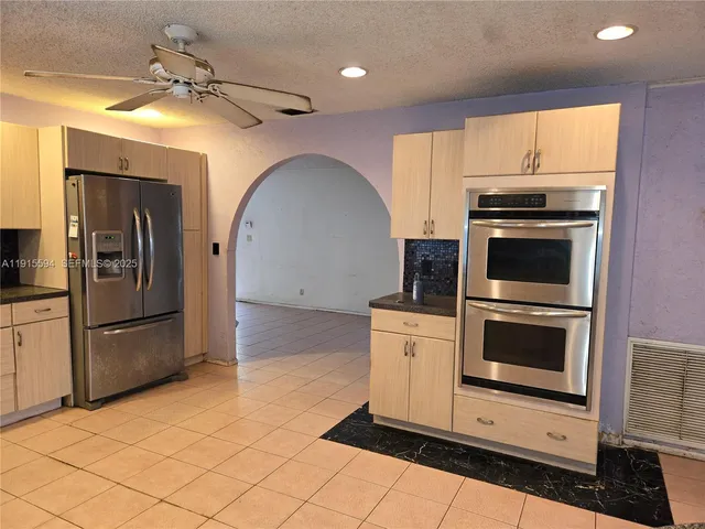 a kitchen with stainless steel appliances granite countertop a stove a microwave and a refrigerator