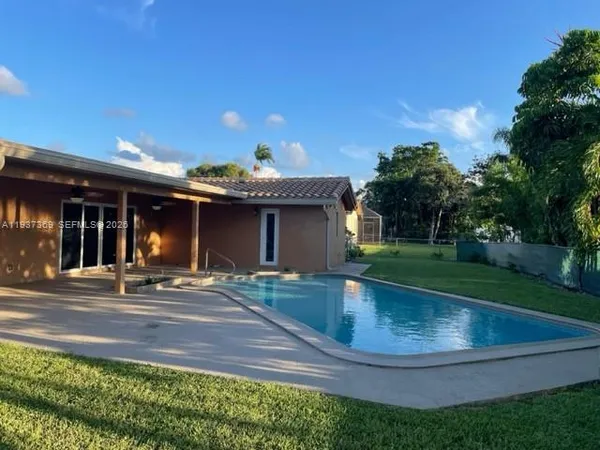 a kitchen with granite countertop a stove a sink and a wooden floor