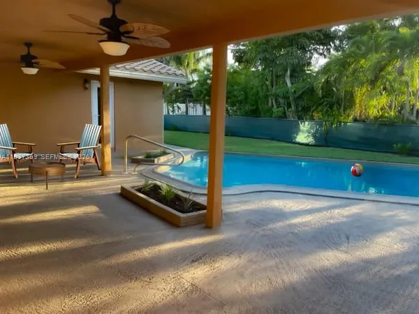 a living room with furniture kitchen and a large window