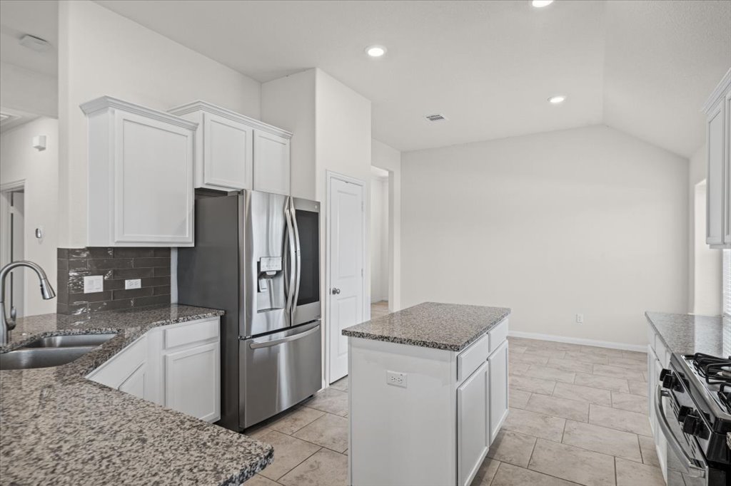 132 Vino Rossi Road Georgetown, TX 78628 - Photo 12 of 35 The pantry , refrigerator and center Island make serving a breeze to the adjacent dining area.