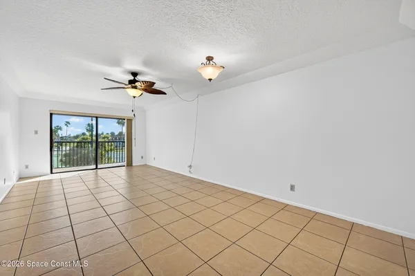 a view of an empty room and a chandelier fan