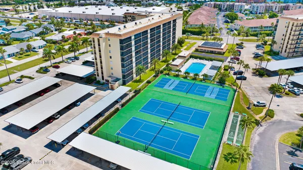 an aerial view of multiple houses with a yard