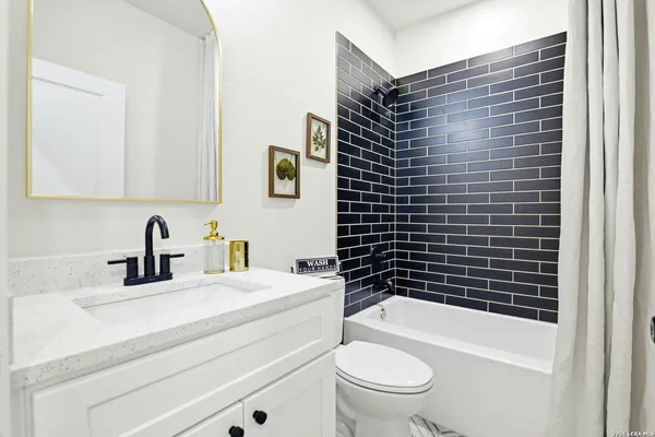 a bathroom with a sink toilet vanity and bathtub
