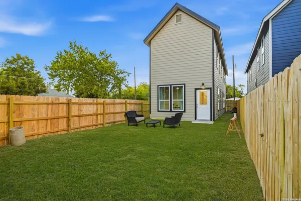 a backyard of a house with table and chairs