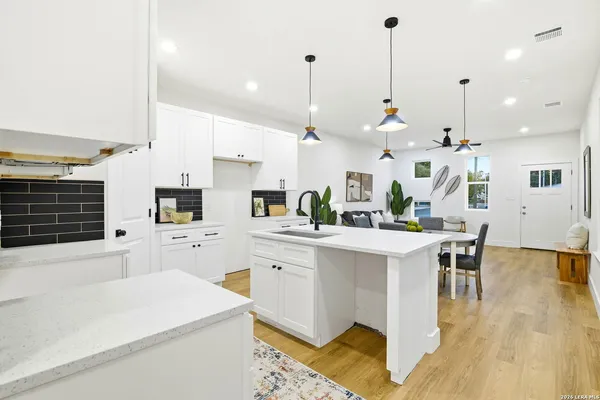a kitchen with kitchen island a white counter top space cabinets and appliances
