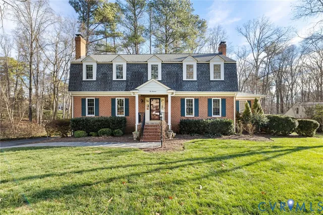 a front view of a residential apartment building with yard and green space