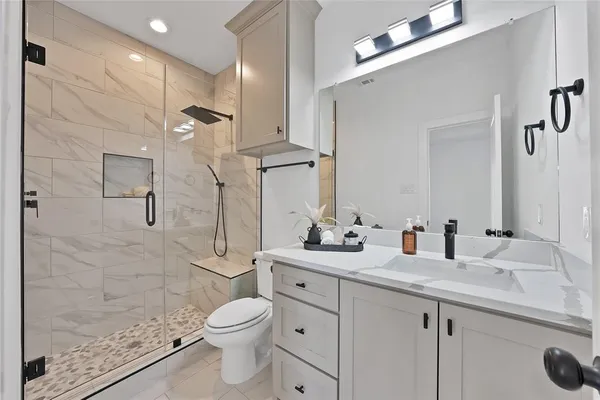 a bathroom with a double vanity sink toilet and shower