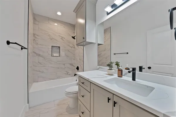 a bathroom with a sink a toilet and shower