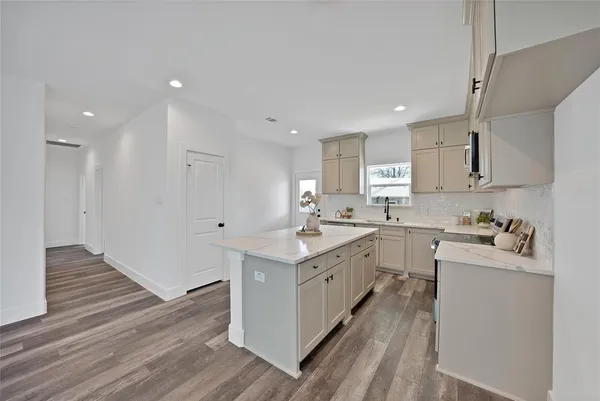 a kitchen with a sink stove and cabinets